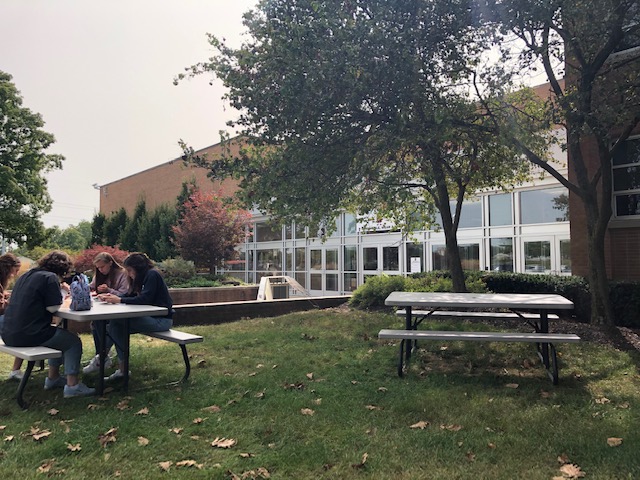 Students gather at a safe distance for lunch in front of school. With hybrid learning, there usually is plenty of space at the tables.