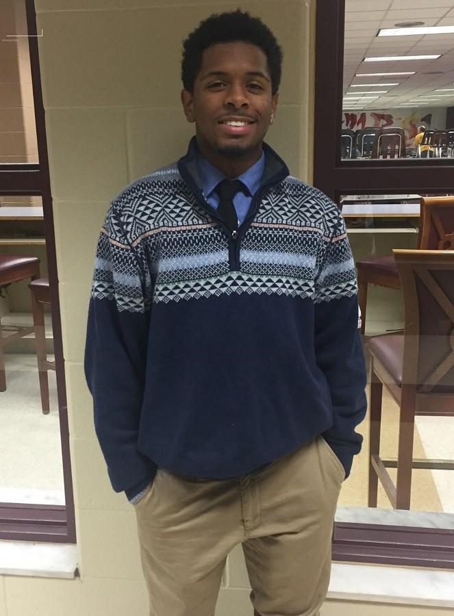 Pictured here on the day of the school year's first convo, senior Deshon Blakely wears a classic blue button down and khakis, enhanced  with a nice quarter-zip sweater. Although Blakely is wearing a cast, attention is drawn away from his injury by the intricate pattern of his navy sweater. The sweater goes great with his black tie and blue shirt. 