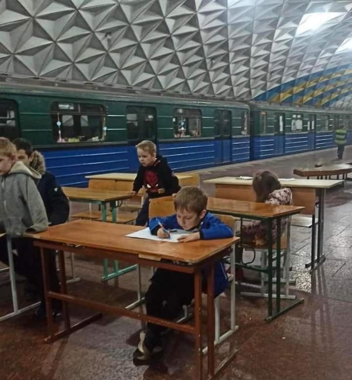 Ukrainian children learn in a train station due to their school being demolished.