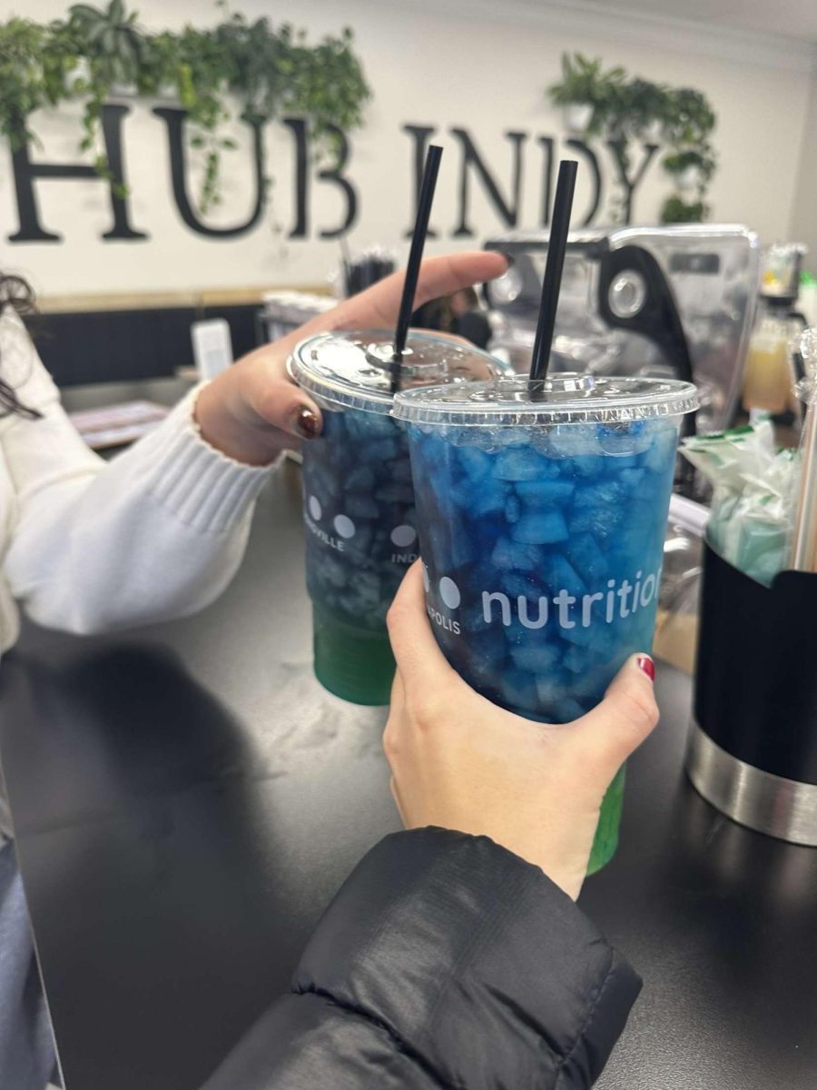 Audrey Edwards '25 and Elise O'Neill '25 cheers with their Nutrition Hub teas 